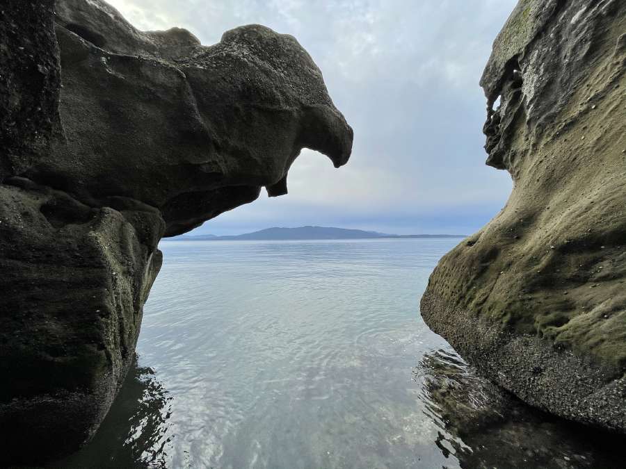 photo of the bay between two rocks.